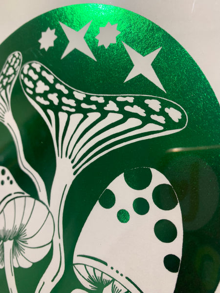 Close up detail of Shiny green foil art print. Hand drawn mushroom elements within a light bulb illustration. A4 sized art print. With Love From Lilibet logo. Foil print in a narrow black frame.